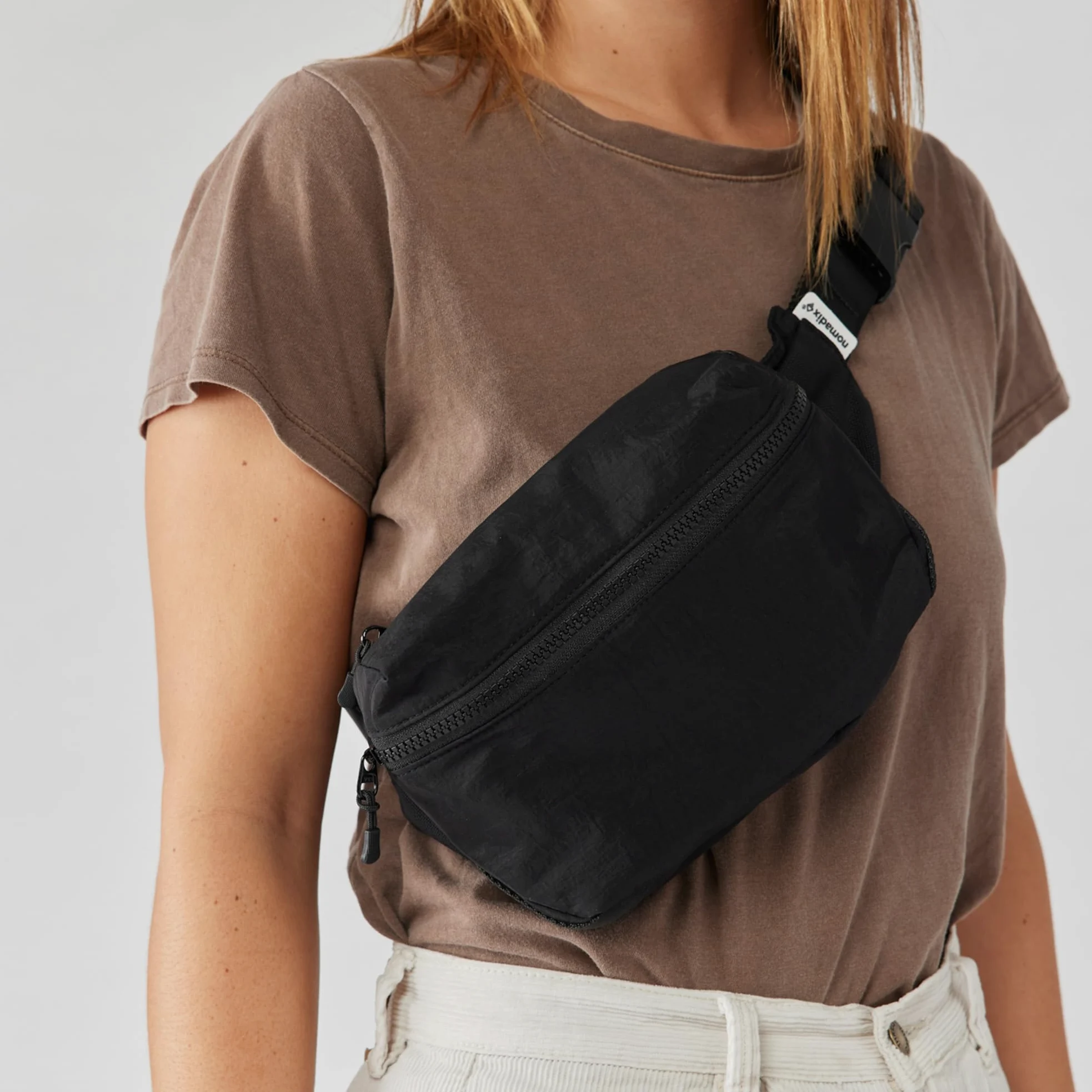 Nomadix Fanny Pack Raven Black - Bolsa cruzada ligera y resistente al agua para senderismo, festivales y viajes, nailon reciclado ecológico con clip para llaves, bolsillos dobles y almacenamiento